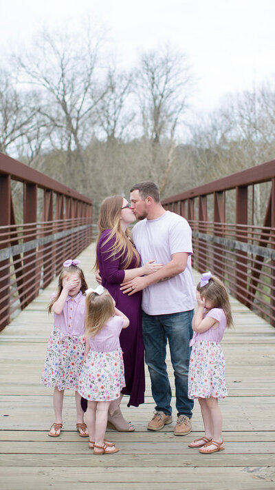 St Augustine family session at the park, mom and dad kissing and little ones running around