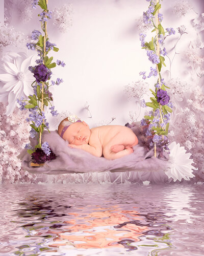 Newborn peacefully posed on a lavender-themed setup with a dreamy water reflection, surrounded by delicate purple flowers. Captured in Overland Park, Kansas, this serene and artistic scene is ideal for families seeking creative newborn photography in the Kansas City area.