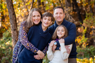 A family of four snuggling among the fall foliage for their Springfield family photography session.