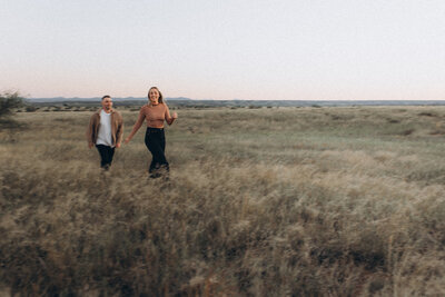 a couple embracing next to a tree in a Scottsdale field