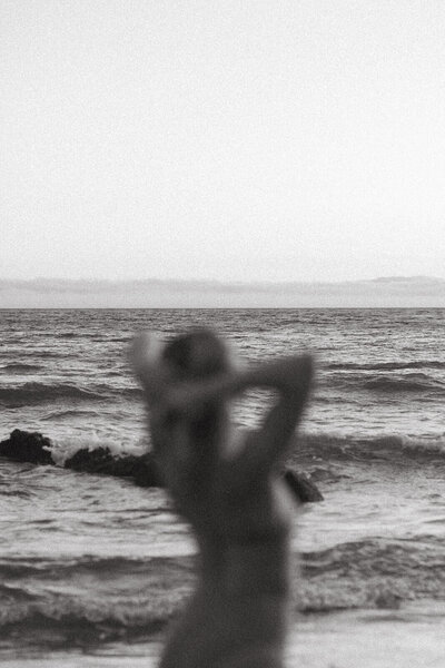 A woman on the beach staring out into the ocean