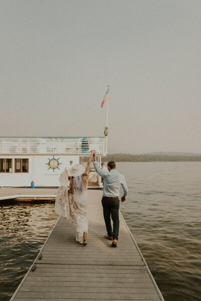Bride and groom on a dock in front of a boat