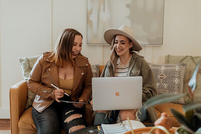 women sitting on couch with computer
