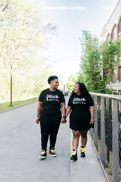 LGBTQ+ couple poses in front of Ponce City Market for engagement photos.