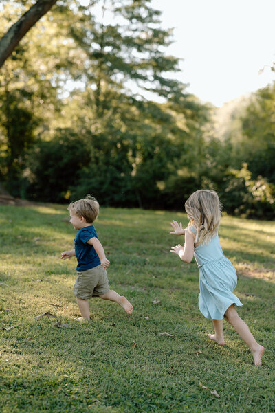 Two little kids joyfully running outdoors, engaged in a delightful chase