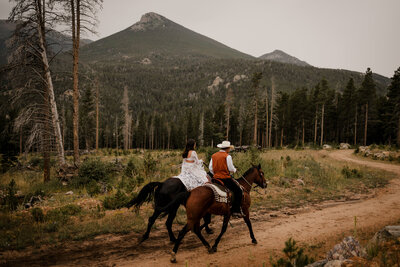 Elopement couple riding horseback in the Colorado Mountains