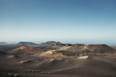 View of Timanfaya National Park in Lanzarote, there are volcanic mountains against the blue sky