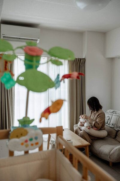 窓際で赤ちゃんにミルクをあげる母親の穏やかな時間、育児のやさしい瞬間