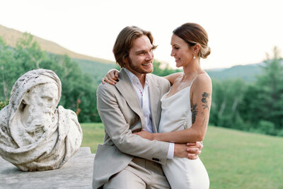 Couple embraces on steps of Wilburton Inn manchester vt wedding in pnni parma beige suit