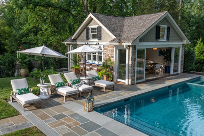 stone wall pool house with pool behind