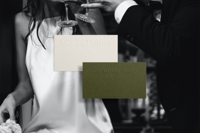 Two embossed business cards. One is off white and the other is olive green.