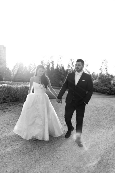 bride and groom holding hands and walking during sunset at their Kentucky wedding 