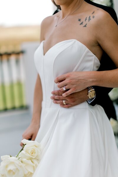 bride and groom holding hands showcasing their rings photo taken by mary wiebe photography