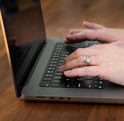 woman's hands typing on a laptop computer