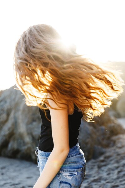 Senior photoshoot on the sand in Malibu, California – teen in denim jeans and black tank top
