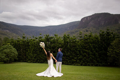 Wedding couple standing in front of a stunning mountain scenery