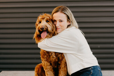 woman hugging big brown dog