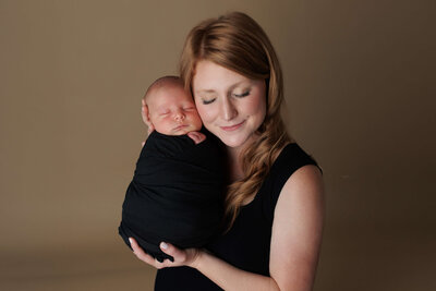mother-and-newborn-baby-in-black-on-tan-background-harrisburg-portrait-newborn-photographer