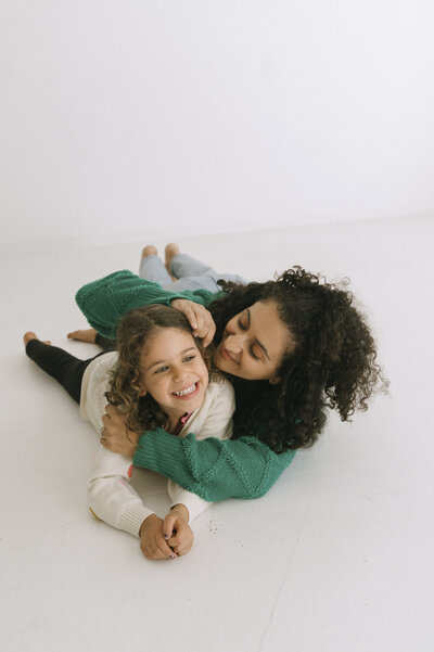 man and woman laying down and looking at baby