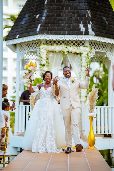 bride and groom smile wide as they walk down the aisle after saying their vows