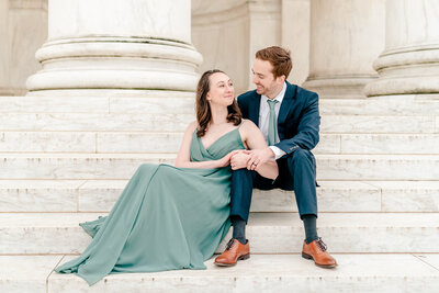 An engaged couple lounges on the steps of the Jefferson Memorial during their engagement session in Washington DC