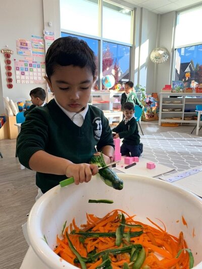 Student carving vegetables in Cloverdale Montessori classroom