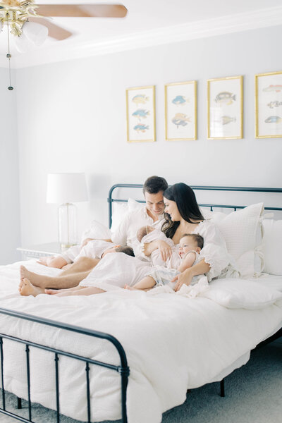Family sitting on bed with newborn by Richmond Newborn Photographer Adrianne Shelton