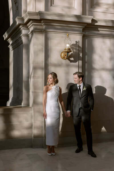 Groom covers his eyes as he sees his beautiful bride on their wedding day at San Juan Capistrano Mission