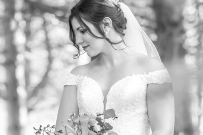 Bride glances over her right shoulder while holding her bouquet
