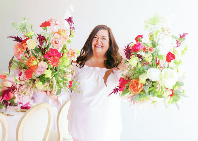 Headshot of Susan Noland in a pink dress in front of a light pink background