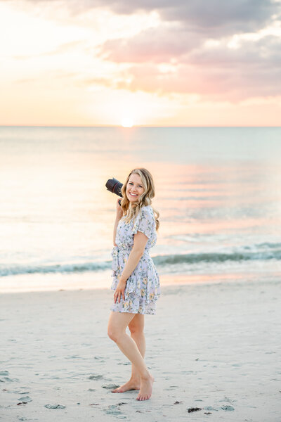 one of the central florida wedding photographers on the beach with her camera