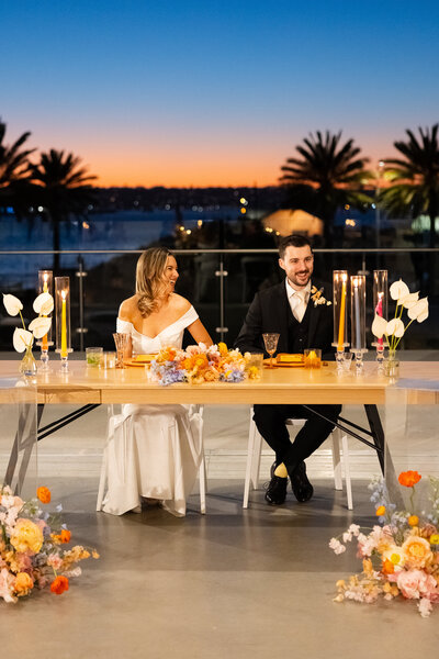 bride and groom enjoying dinner during sunset