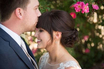 groom kissing bride on forehead