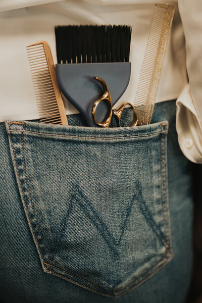 hair cutting and color tools in a stylist back pocket