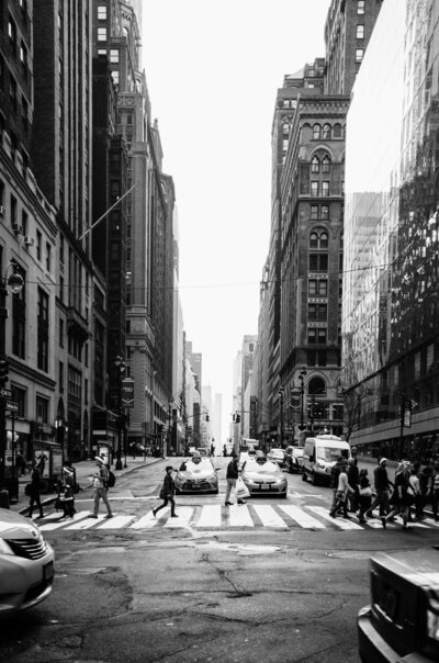 Urban street scene with pedestrians crossing and tall buildings, representing dynamic and creative environments.