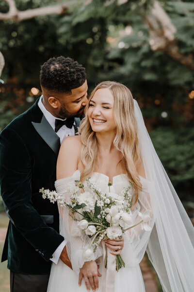 bride and groom embracing while smiling