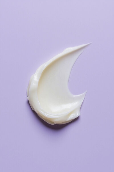 Dollop of face cream on a purple bacdrop