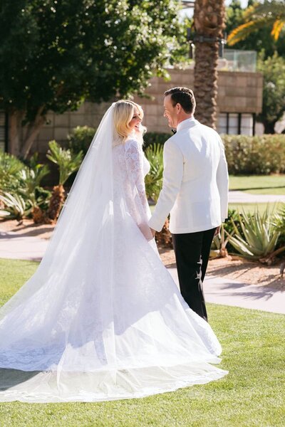 Bride and groom walking hand in hand on the lawn at Arizona Biltmore Weddings, captured by Arizona Biltmore Wedding Photographers.