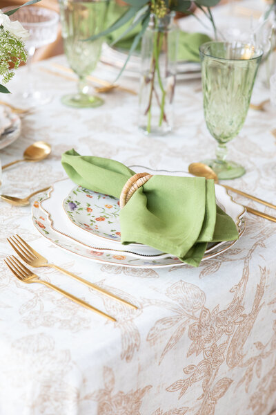 An Austin-based wedding photographer captures a beautifully arranged place setting featuring green napkins and gold forks.
