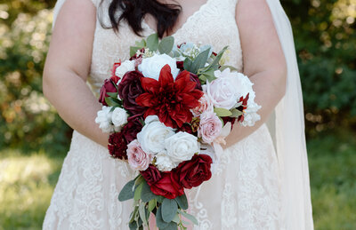 Close-up of an elegant wedding bouquet featuring seasonal flowers, lush greenery, and soft romantic tones, perfect for a timeless bridal look.