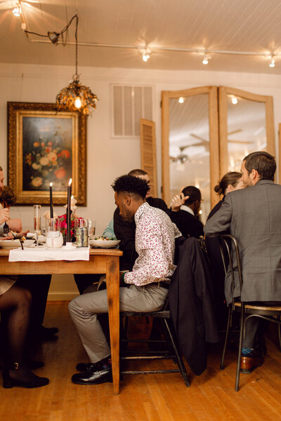 Guests taking their seats at a beautifully set dinner table during an intimate indoor wedding reception in Richmond, Virginia.
