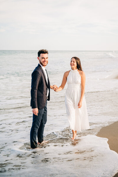 couple walking in the water on the beach