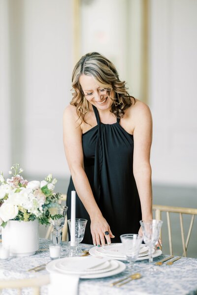 wedding planner putting final touches on table setting