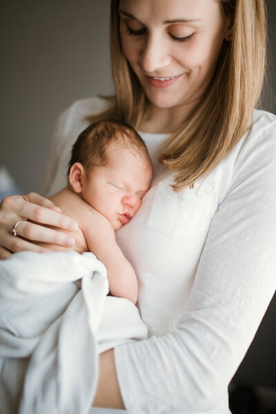 Ashley Hodges take photo of mama holding newborn baby beside a window