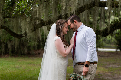 a wedding couple standing forehead to forehead 