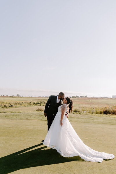 newlyweds kissing on golf course