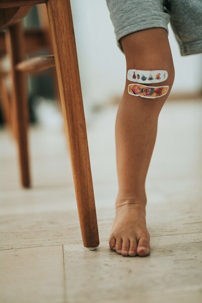 Zwei Pflaster auf dem Knie eines Kindes.