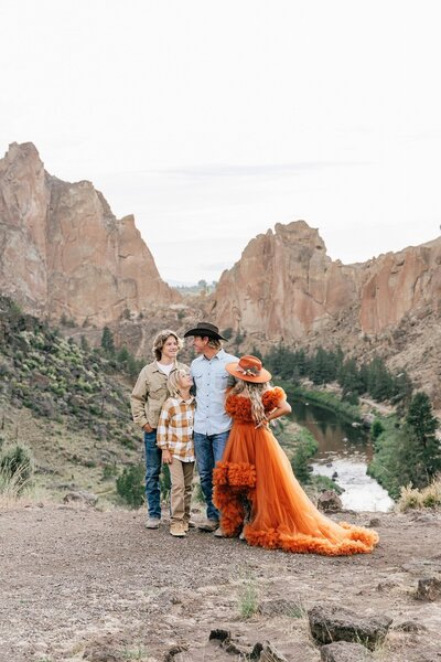 A western boho themed family portrait at Oregon's Smith Rock State Park near Bend, featuring an orange tulle dress and hat. | Erica Swantek Photography