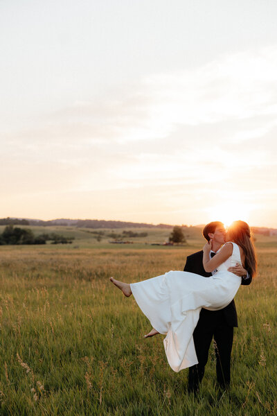 Christian holding Olivia at their wedding at The Farmhouse Barn.
