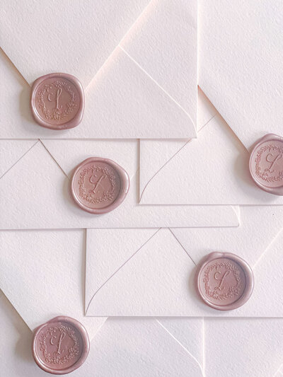 Wax seal closures on blush paper wedding invitation envelopes